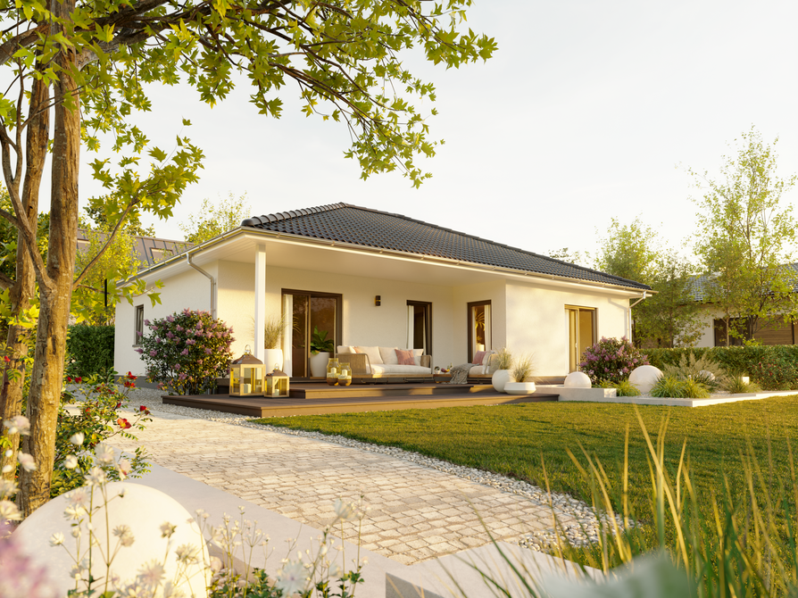 Gesamtansicht des Gartens vom Winkelbungalow 108 mit überdachter Terrasse im Winkel, großer Rasenfläche und üppiger Bepflanzung.